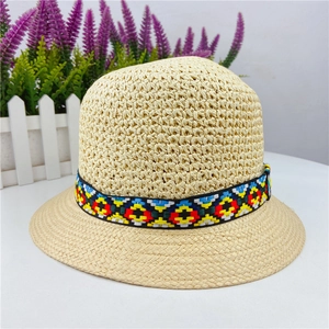 Close-up of handmade hollow breathable straw hat with colorful ethnic pattern band