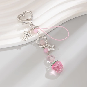 Détail de porte-clés fraise avec fermoir cœur, perles et ornement de nœud rose