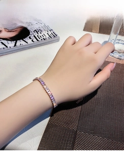 Detail of rose gold tennis bracelet with baguette cut zircon stones on a female wrist