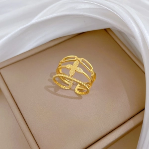 Detailed close-up of gold clover ring with delicate micro-pave crystals on fabric