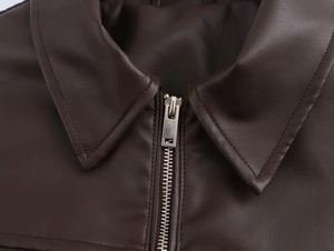 Macro detail of dark brown faux leather pilot jacket collar and silver metal zipper