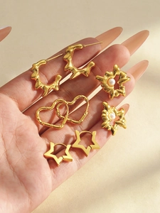 Detail of 304 stainless steel gold earring set with double hearts and pearl accents