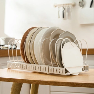 Close-up of adjustable cream metal dish rack with neatly organized ceramic plates