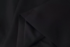 Macro shot of high-quality black woven fabric texture and precise stitching on the garment