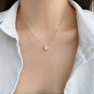Detail view of a square-cut sparkling zircon pendant on a silver-plated chain necklace