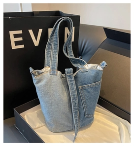 Detail of vintage denim bucket bag with dual-tone patchwork and external pocket design