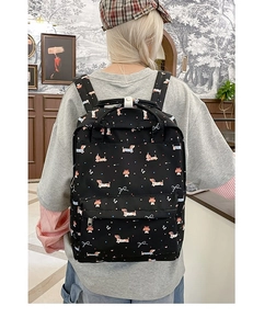 Detail of black backpack with cute dachshund dog print worn by model in vintage setting