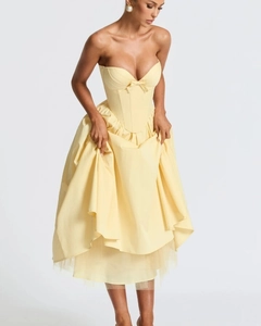 Detail of a pale yellow corset dress featuring a strapless neckline and a small bow tie