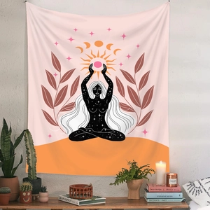 Detail of bohemian sun and moon yoga tapestry hanging above plants and candles
