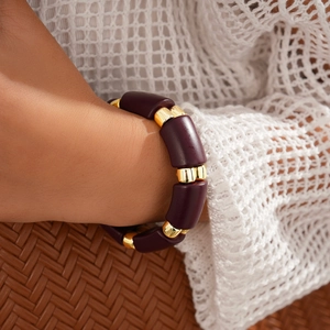 Detail of purple acrylic cylinder beads and gold metal spacers on a boho style bracelet