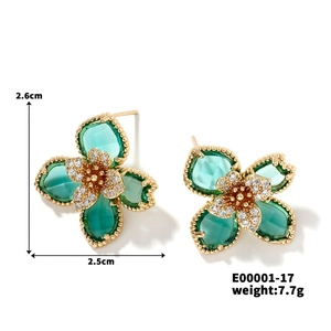 Vue détaillée des boucles d'oreilles fleur dorées avec pierres vertes et cristaux brillants