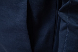 Macro shot of dark blue knit jacket fabric showing detailed stitching on pocket opening
