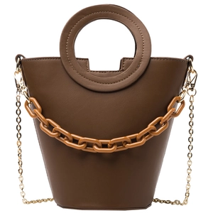 Deep brown bucket bag with round handle, amber chain detail and metallic strap