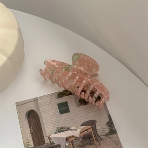 Macro view of floral marble acetate hair claw clip with pink and green textured finish