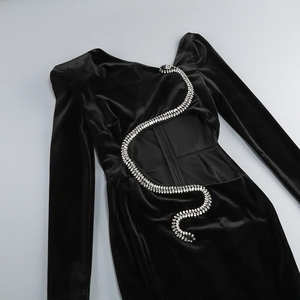 Detail of the open back with a snake-shaped rhinestone decoration on a black velvet dress