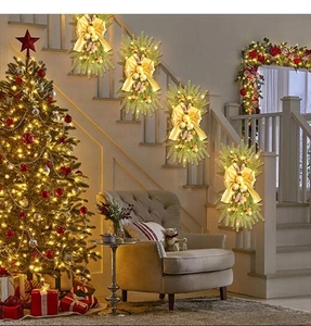 Detailed view of illuminated Christmas teardrop wreaths with gold bows and pine cones