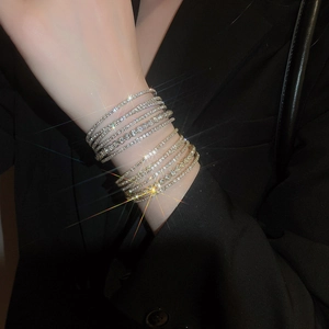 Macro detail of multilayered sparkling rhinestone bracelet set in silver and gold tones