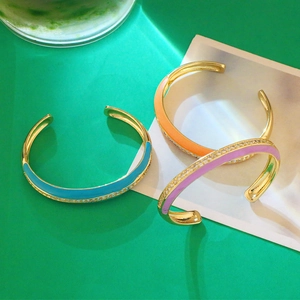 Dettaglio dei bracciali rigidi a C in smalto colorato con accenti in zirconia cubica