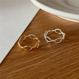 Minimalist 925 sterling silver twisted open rings in gold and silver on wood desk