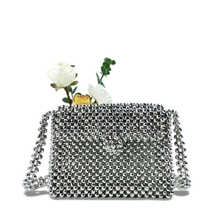 Detailed close-up of silver beaded crossbody bag with glossy hand-woven pearls