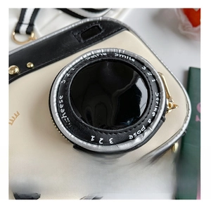 Detail view of a creative camera-style crossbody bag with PU leather and Say Cheese text