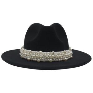 Detail of white pearl decorative band on black wide-brimmed wool felt fedora hat