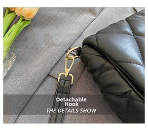 Detail of high-quality gold swivel metal hook on black quilted leather crossbody bag