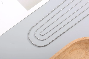 Detailed view of three polished silver snake bone chains in different length specifications