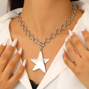 Detail of silver star pendant necklace with thick chain and OT toggle clasp on model