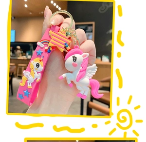 Detail of pink cartoon unicorn keychain with star pendant and matching rubber hand strap