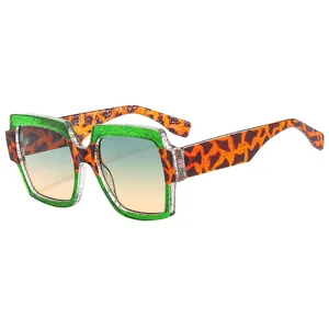 Oversized square sunglasses with green glitter upper frame and leopard print lower frame