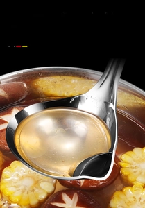 Macro view of stainless steel oil separator spoon pouring clear soup broth