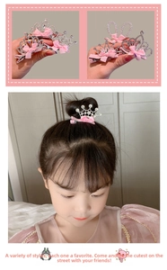 Detail of glittery crown hair clip with rhinestones and pink ribbon bow for girls