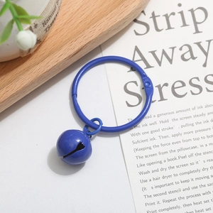 Close-up of blue lacquer metal ring with matching bell charm for DIY accessories