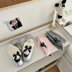 Detail of silver ballet flats with ribbons and lace socks in grey, beige and pink colors