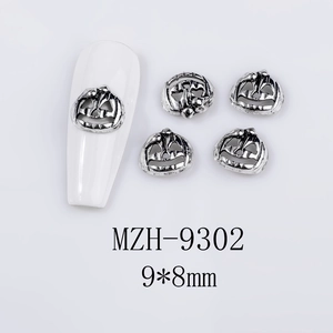 Macro detail of pumpkin nail art charms 9x8mm in vintage silver metal for Halloween DIY