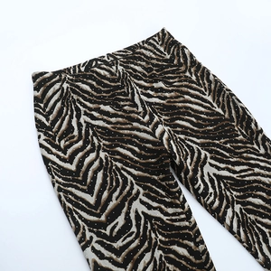 Macro detail of leopard print flare pants featuring shimmering sequins and elastic waist