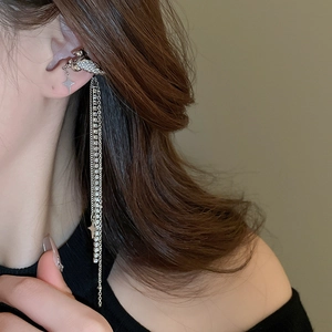Close-up of silver tassel earrings with stars and cubic zirconia on a female model