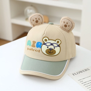 Detail of a beige cotton cap with green brim, 3D bear ears and Air Patrol cartoon print