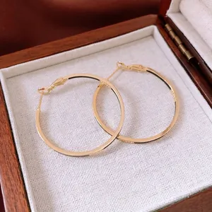 Classic 14k gold plated round hoop earrings displayed on a premium wooden jewelry box