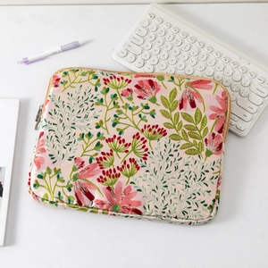 Close-up of pink quilted laptop sleeve with red floral pattern and zipper detail