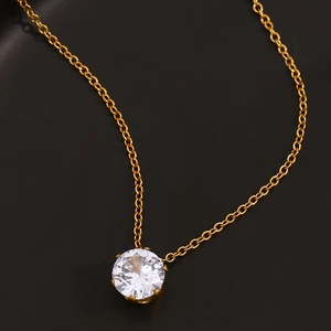 Vue macro d'un pendentif couronne en zircon blanc étincelant sur une fine chaîne dorée