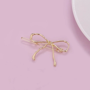 Elegant gold bow-shaped metal hair clip with a minimalist finish for women's styling
