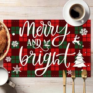 Red and green plaid Christmas placemat with Merry and Bright text on wooden table