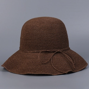 Detailed close-up of dark brown crochet straw sun hat featuring intricate woven texture