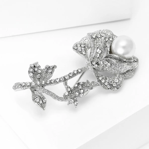 Close-up of vintage silver rose brooch with white pearl and sparkling rhinestones