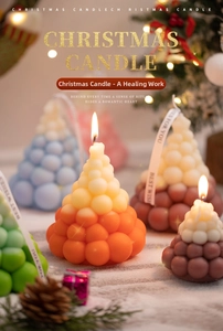 Detailed view of layered Christmas tree scented candles with decorative Best Wishes ribbons