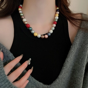 Close-up of vibrant multi-colored large faux pearl necklace on a model's neck