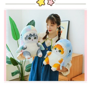Detail of plush cat toys in shark costumes with gray and orange fur in cozy setting