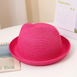 Détail d'un chapeau de paille rose pour enfant avec des oreilles de chat décoratives mignonnes